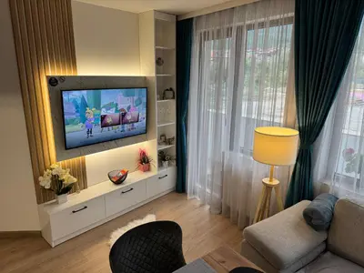 a living room with a tv on a wall at Anna Lux in Bansko