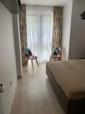a bedroom with a bed and two chairs and a window at Kirmini apartment in Sofia