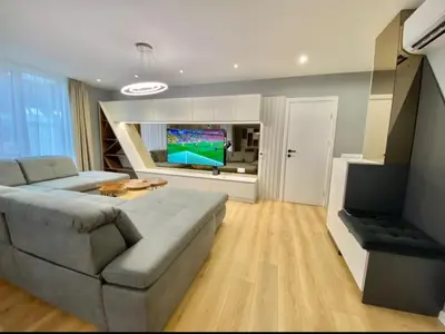 a living room with a couch and a flat screen tv at Gran Capital - Vodolei Park, FREE parking in Sofia
