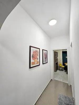 a hallway with two pictures on a white wall at Апартамент Лилия in Gotse Delchev