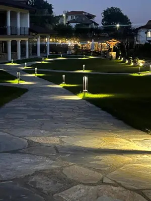 a walkway in front of a building at night at SPA Apartament Daffi in Smolyan
