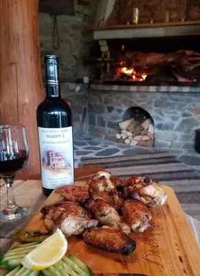 a bottle of wine next to a plate of food and a bottle of shrimp at SPA Apartament Daffi in Smolyan