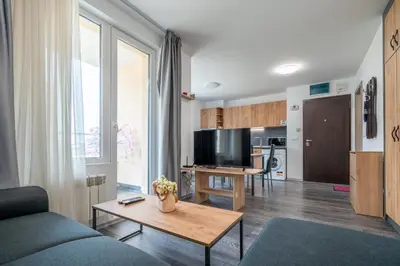 a living room with a couch and a table at Cardinal Suite in Sofia