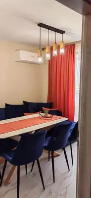 a dining room with a table and blue chairs at Apartmenthaus Oborishte - 24 in Panagyurishte