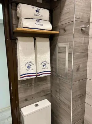 a bathroom with a toilet and a bunch of towels at Бутиково студио Joy-free parking in Plovdiv