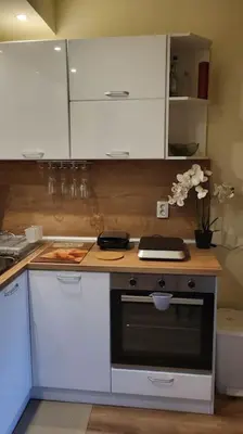 a kitchen with white cabinets and a stove at Diamond of Crown Bansko by Flat Mаnager in Bansko