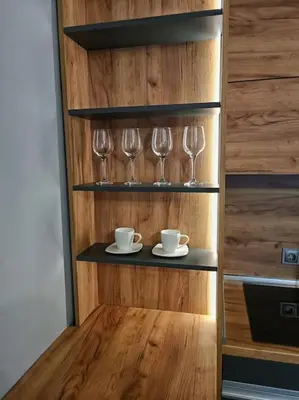 a shelf with wine glasses and saucers on it at Бутиково студио Utopia in Plovdiv