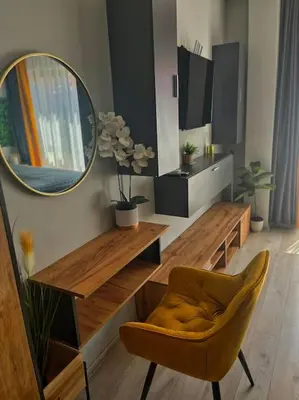 a living room with a mirror and a table and a chair at Бутиково студио Utopia in Plovdiv