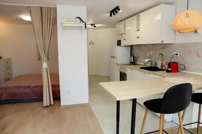 a small kitchen with a table and a bed at Sophie Studio - Top center, Cozy & Work-Friendly near AUBG, Free streaming platforms in Blagoevgrad
