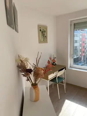a dining room with a table and a vase with flowers at Sophie Studio - Top center, Cozy & Work-Friendly near AUBG, Free streaming platforms in Blagoevgrad