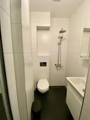 a white bathroom with a toilet and a sink at Удобен апартамент в центъра на София in Sofia
