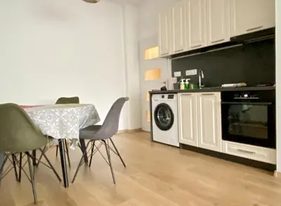 a kitchen with a table and chairs and a microwave at Удобен апартамент в центъра на София in Sofia