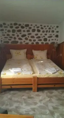 a wooden bed with two pillows on top of it at Matsureva House - Pri Ivan in Bansko