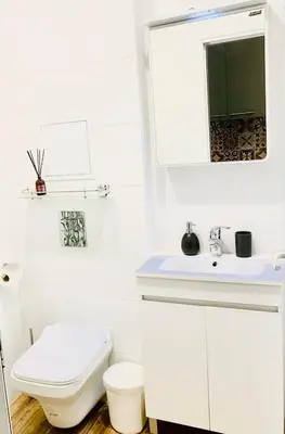 a white bathroom with a toilet and a sink at Little Paris with Free Garage Near Tokuda Hospital in Sofia
