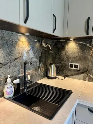 a kitchen counter with a sink and a stove at Business Park Sofia Cozy Lux & Private Garage Option in Sofia