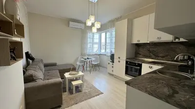 a kitchen and living room with a couch and a table at Скобелев 48 in Sofia