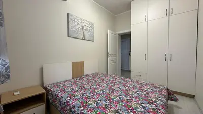 a small bedroom with a bed and white cabinets at Скобелев 48 in Sofia