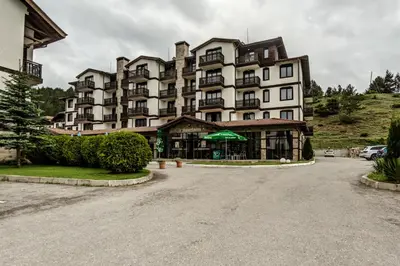 a large apartment building with a parking lot in front of it at Bansko Cozy Peak in Bansko