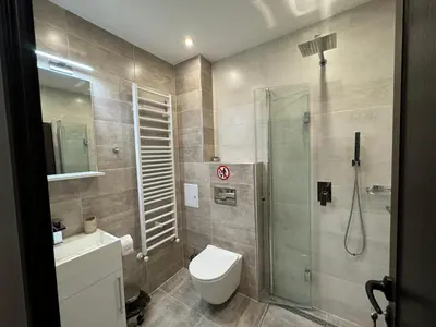 a bathroom with a toilet and a glass shower at Къща за гости Лъките in Divchovoto