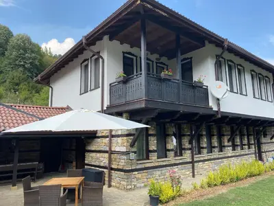 a house with a balcony and a wooden table at Къща за гости Лъките in Divchovoto