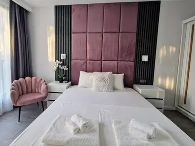 a bedroom with a large white bed and a pink headboard at Sun Home in the Heart of Plovdiv - Central Location - Free Private Parking in Plovdiv