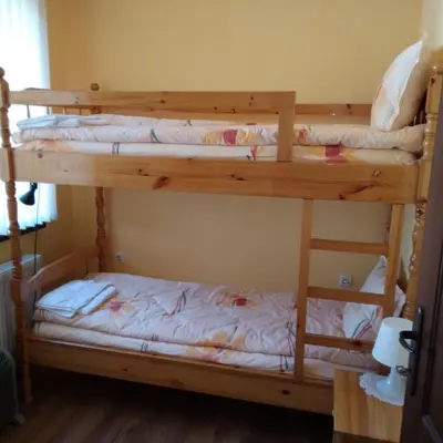 two bunk beds in a room with white sheets at Tainov House in Samokov