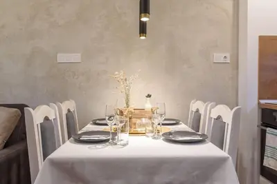 a dining room table with a white table cloth and chairs at Vutovi's corner made with care in Bansko