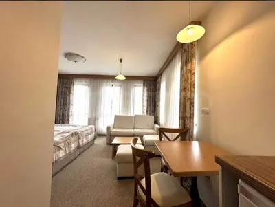 a hotel room with a bed and a table and chairs at Cozy studio in Green Life Bansko in Bansko