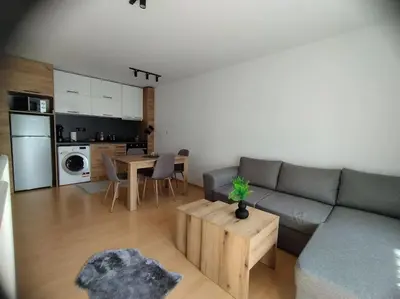 a living room with a couch and a table at Aпартамент Тити in Pamporovo