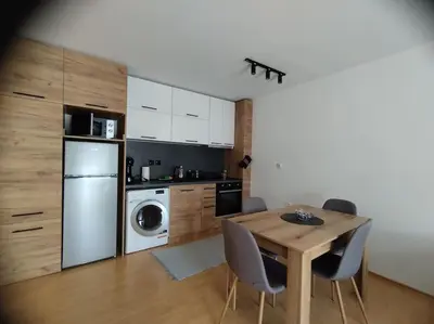 a kitchen with a table and a kitchen with a washer at Aпартамент Тити in Pamporovo