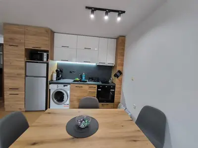 a kitchen with a wooden table and chairs in a room at Aпартамент Тити in Pamporovo