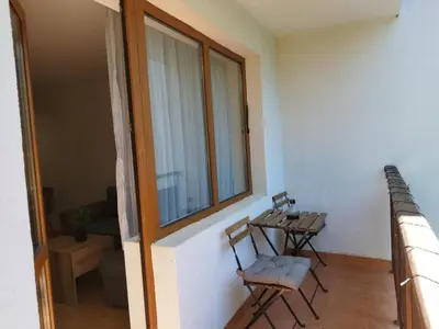 a balcony with a table and chairs in a room at Aпартамент Тити in Pamporovo