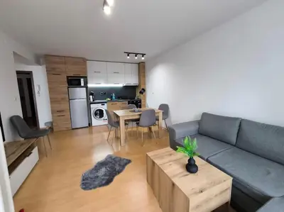 a living room with a blue couch and a table at Aпартамент Тити in Pamporovo
