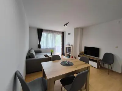 a living room with a table and a couch at Aпартамент Тити in Pamporovo