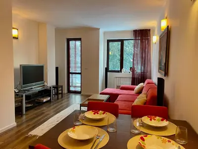 a living room with a red couch and red chairs at Stenata Boutique Apartments in Pamporovo