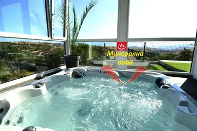 a jacuzzi tub in a room with a window at Hit Hot House in Sandanski