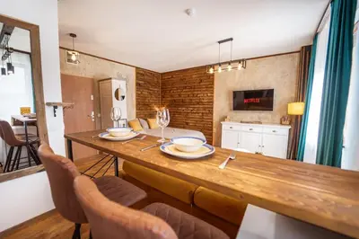 a dining room with a wooden table and chairs at Mountain Studio - Ski in and out - FREE Spa in Bansko