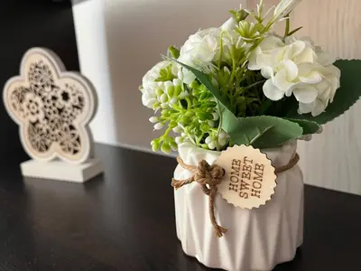 a vase filled with white flowers on a table at Ideal Center by the Park - Walk to Kapana in Plovdiv