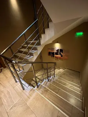 a metal staircase in a room with a green light at Ideal Center by the Park - Walk to Kapana in Plovdiv