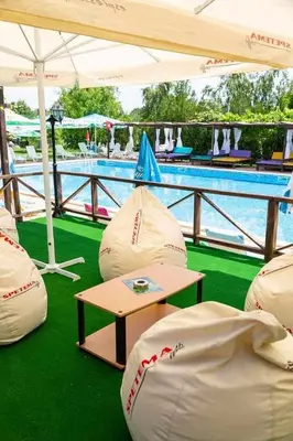a pool with white bean bags next to a table at Комплекс Тракийски стан in Asenovgrad