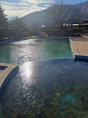 a large pool of water with mountains in the background at Комплекс Тракийски стан in Asenovgrad
