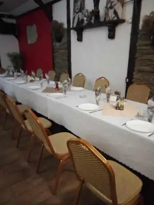 a long white table with chairs and plates on it at Комплекс Тракийски стан in Asenovgrad