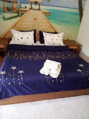 a bed with towels and a painting of a boat at Комплекс Тракийски стан in Asenovgrad