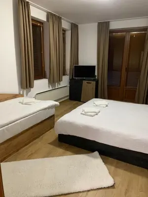 a hotel room with two beds and a television at PAMPOROVO Raikovski lodge in Pamporovo