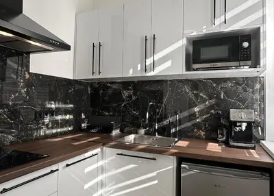 a kitchen with white cabinets and a sink and a microwave at Chill Out Urban Studio in Plovdiv