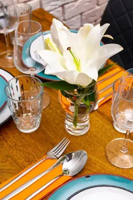 a white flower in a vase on a wooden table at Hidden Gem in the Heart of Plovdiv in Plovdiv