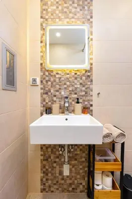 a bathroom with a white sink and a mirror at Hidden Gem in the Heart of Plovdiv in Plovdiv