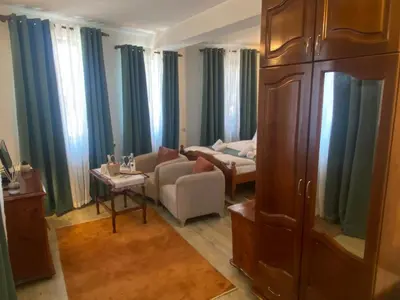 a living room with blue curtains and a couch at Dvata Smurcha Central Apartments - Free Parking in Bansko