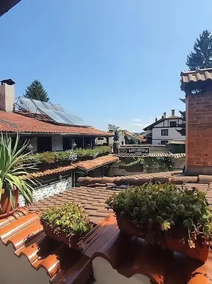 a patio with potted plants on top of a building at Dvata Smurcha Central Apartments - Free Parking in Bansko