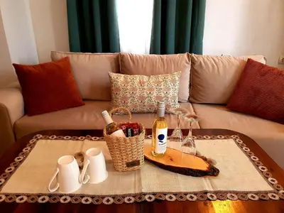 a living room with a couch with a table with wine bottles at Dvata Smurcha Central Apartments - Free Parking in Bansko